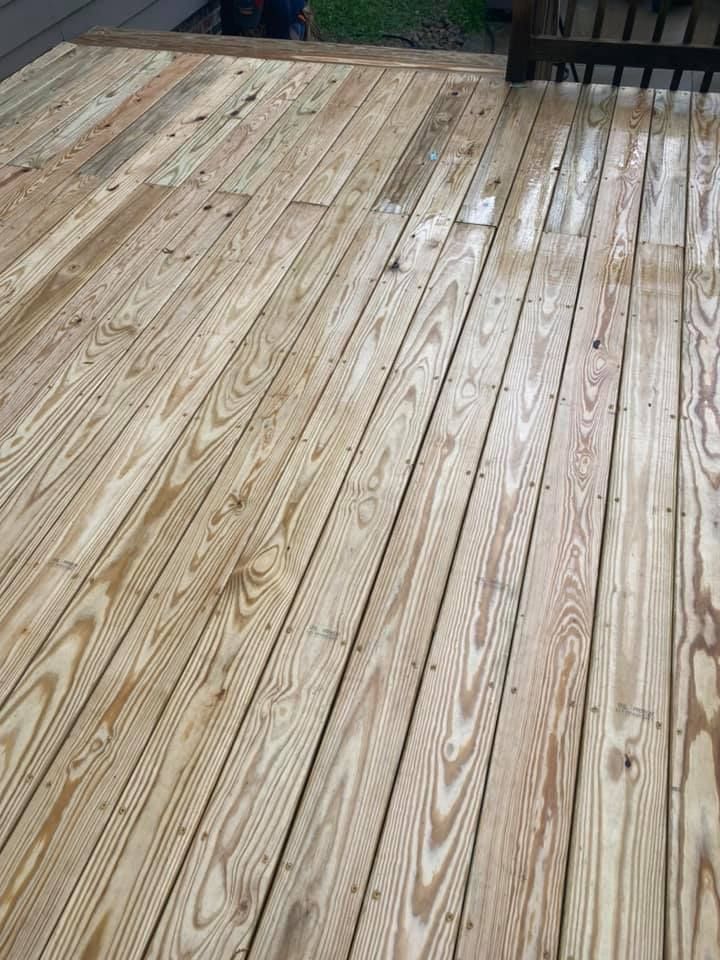 A close up of a wooden deck with a fence in the background.