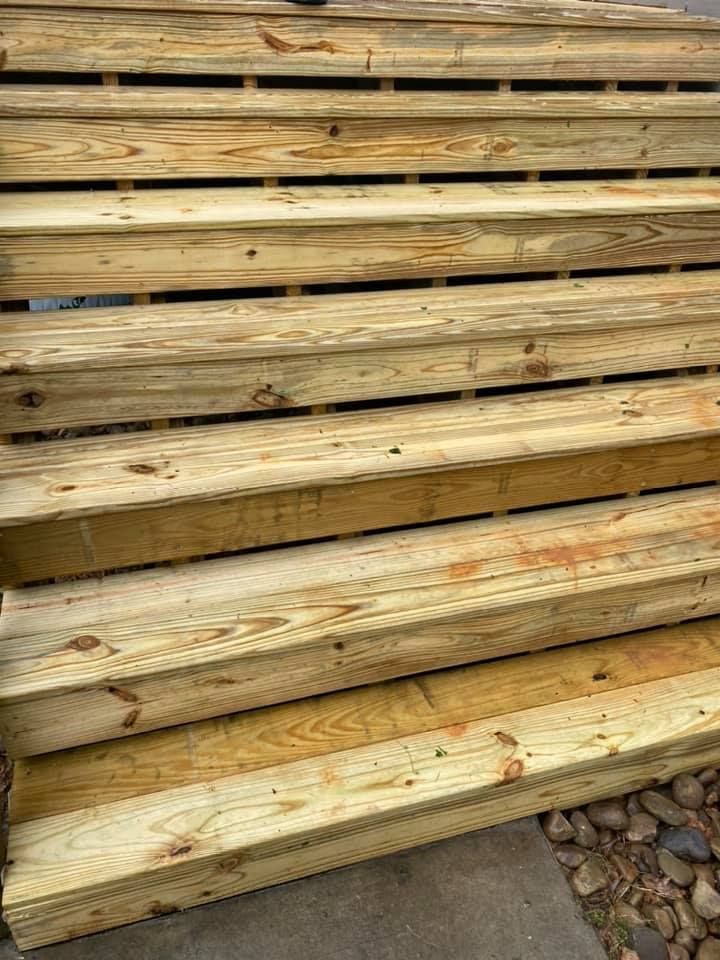 A pile of wooden steps sitting on top of each other on a sidewalk.