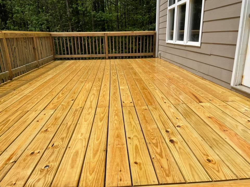 A wooden deck in front of a house with a window.