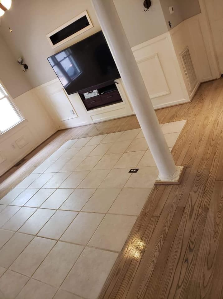 A living room with hardwood floors and a flat screen tv on the wall.