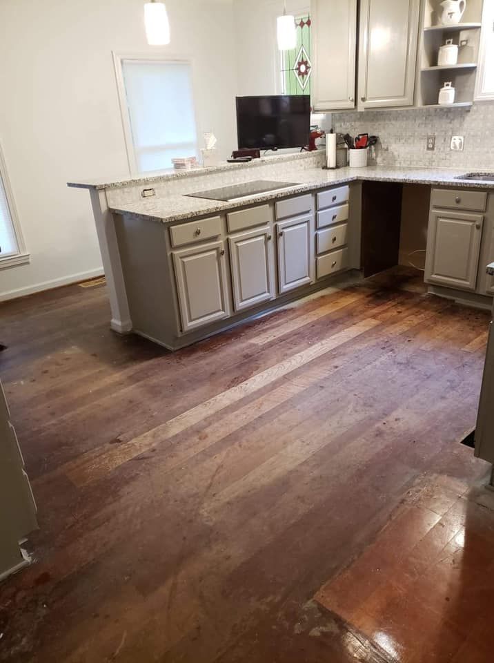 A kitchen with a wooden floor and gray cabinets.