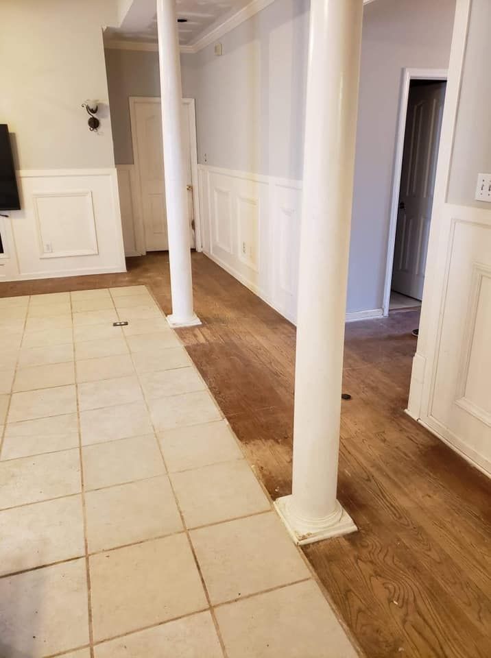 A living room with hardwood floors and white columns.