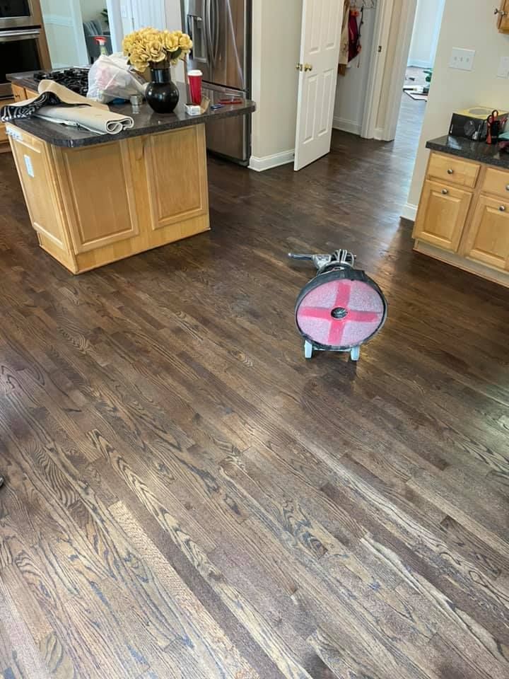 A kitchen with hardwood floors and a pink scooter on the floor.