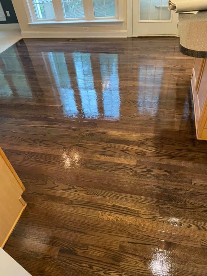 A kitchen with a shiny wooden floor and a window.