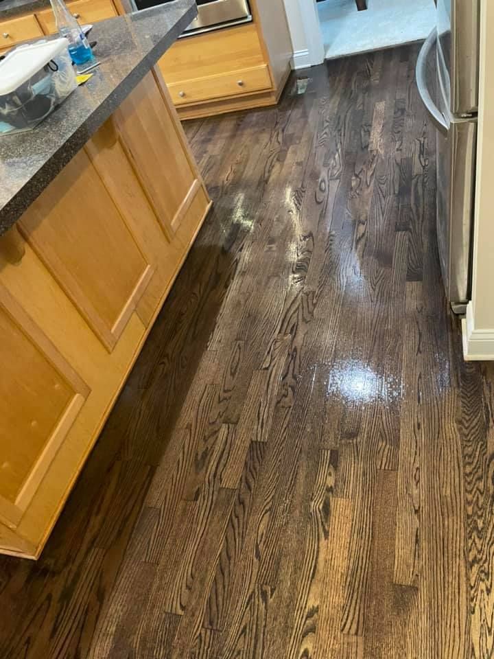A kitchen with hardwood floors and wooden cabinets.