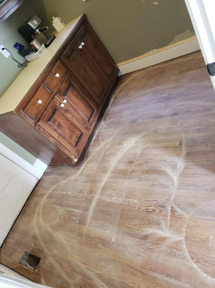 A kitchen with wooden cabinets and a wooden floor.