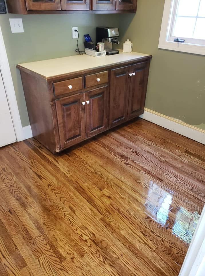 A kitchen with hardwood floors and cabinets and a coffee maker.