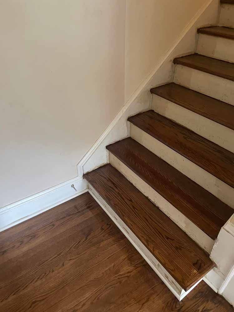 A staircase with wooden steps and a white railing in a house.
