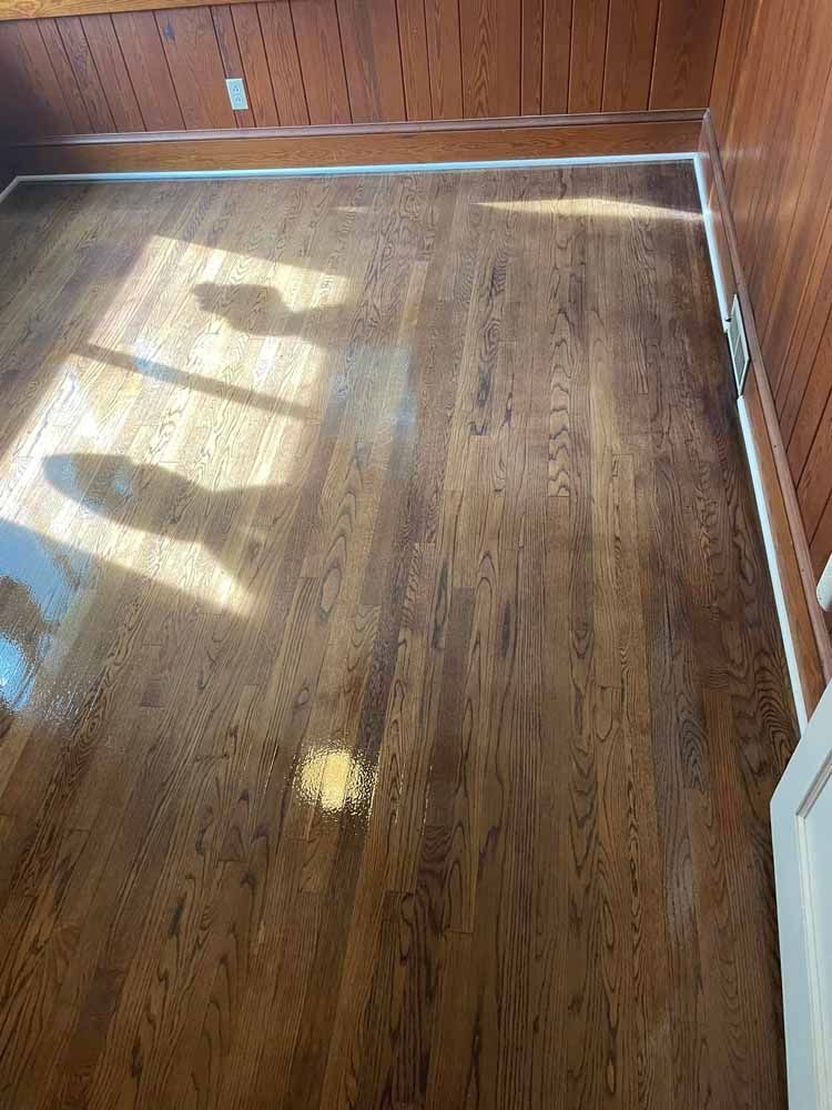 A room with a wooden floor and a window.