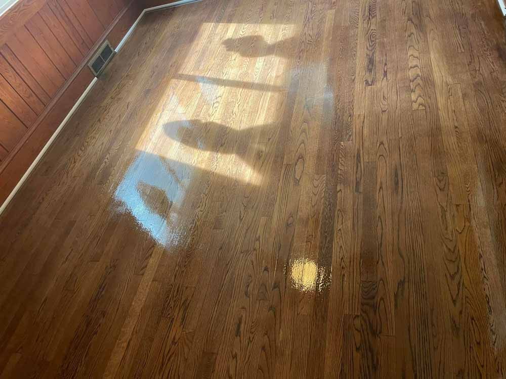 A living room with a wooden floor and a window.