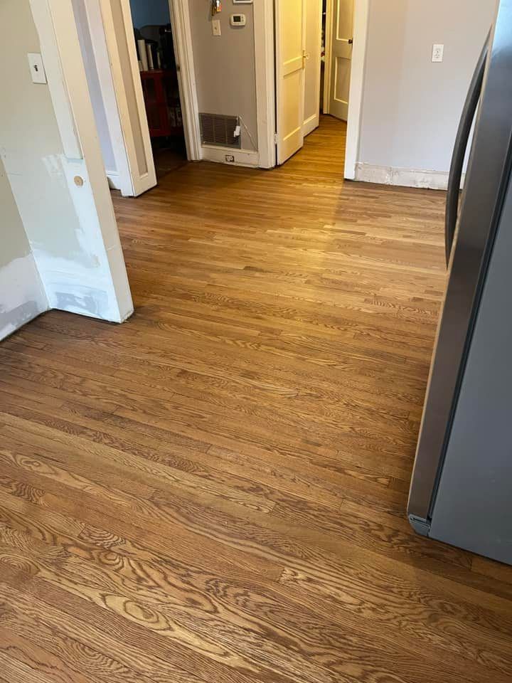 A kitchen with hardwood floors and a refrigerator.