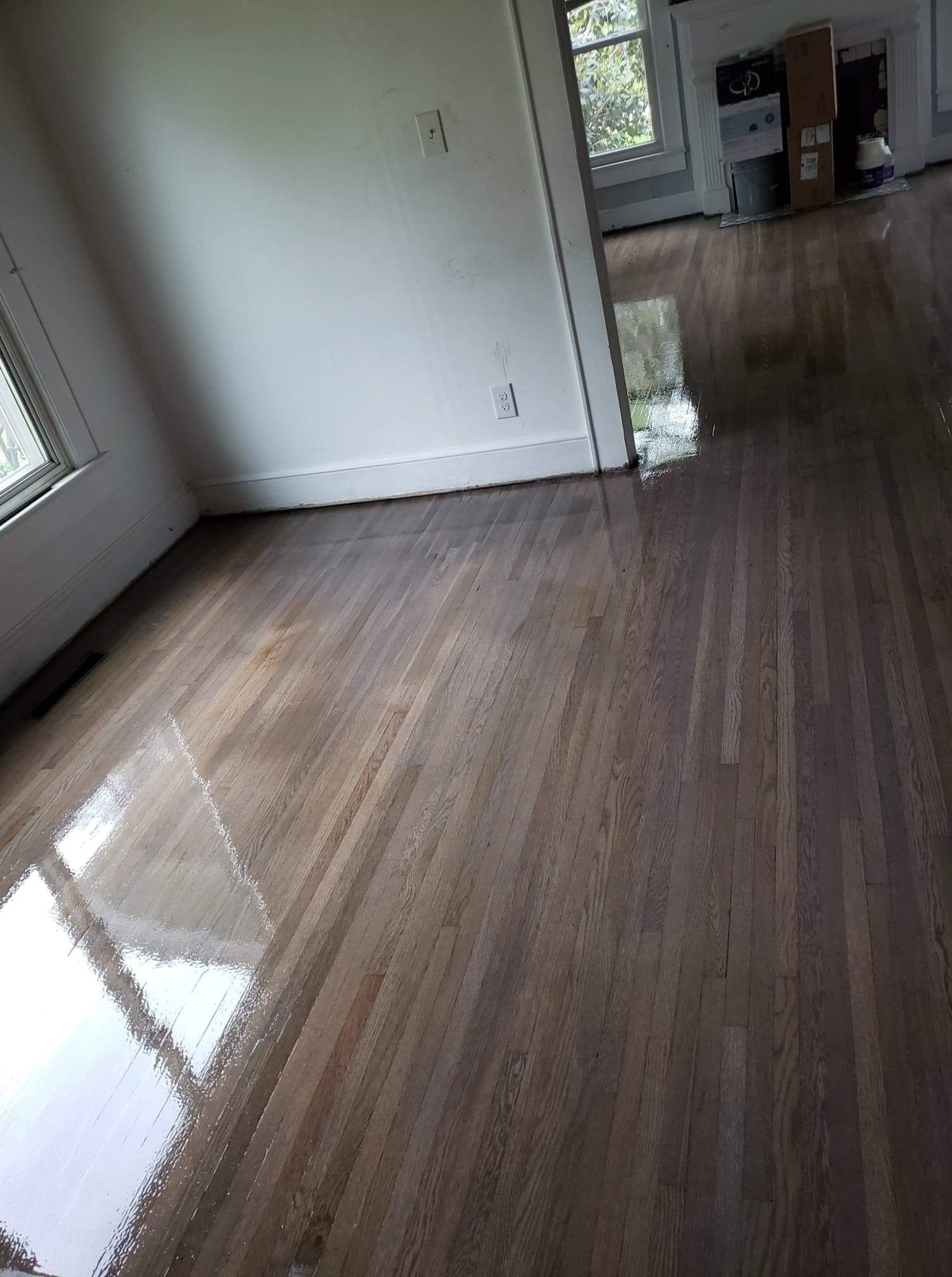 A living room with a wooden floor and white walls.