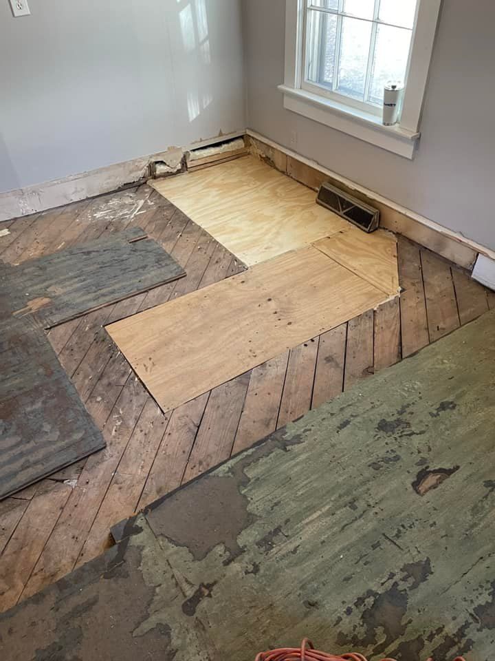 A room with a wooden floor and a window.