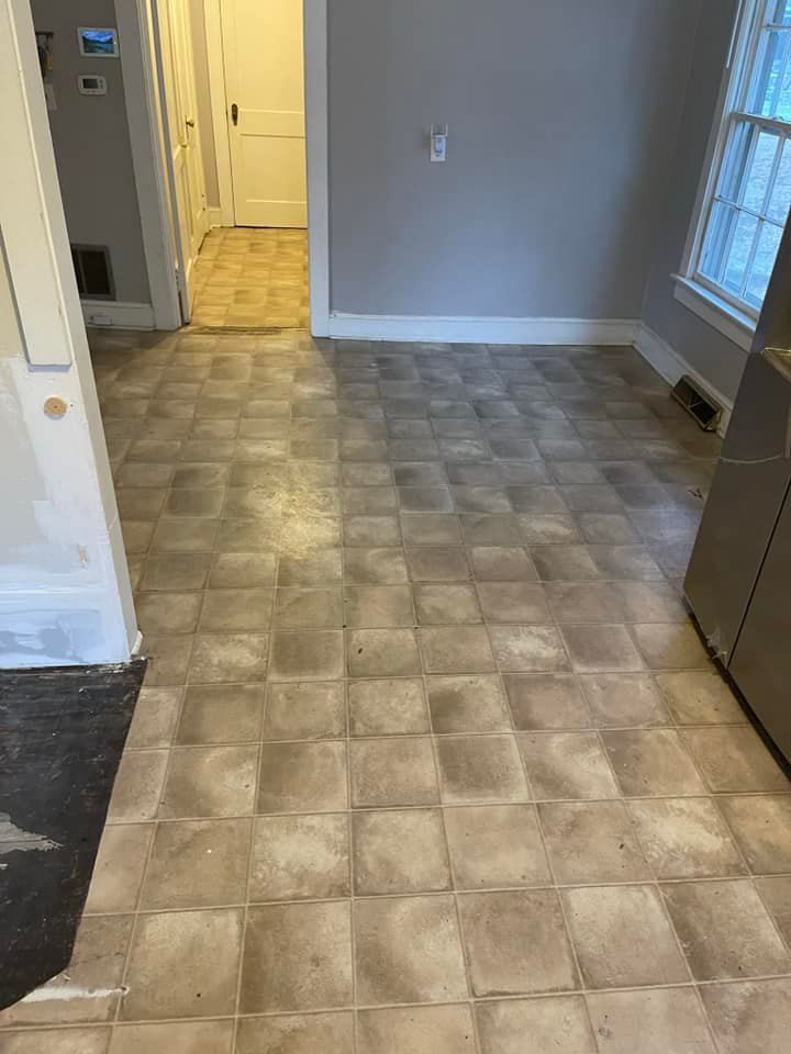 A kitchen with a tile floor and a window.
