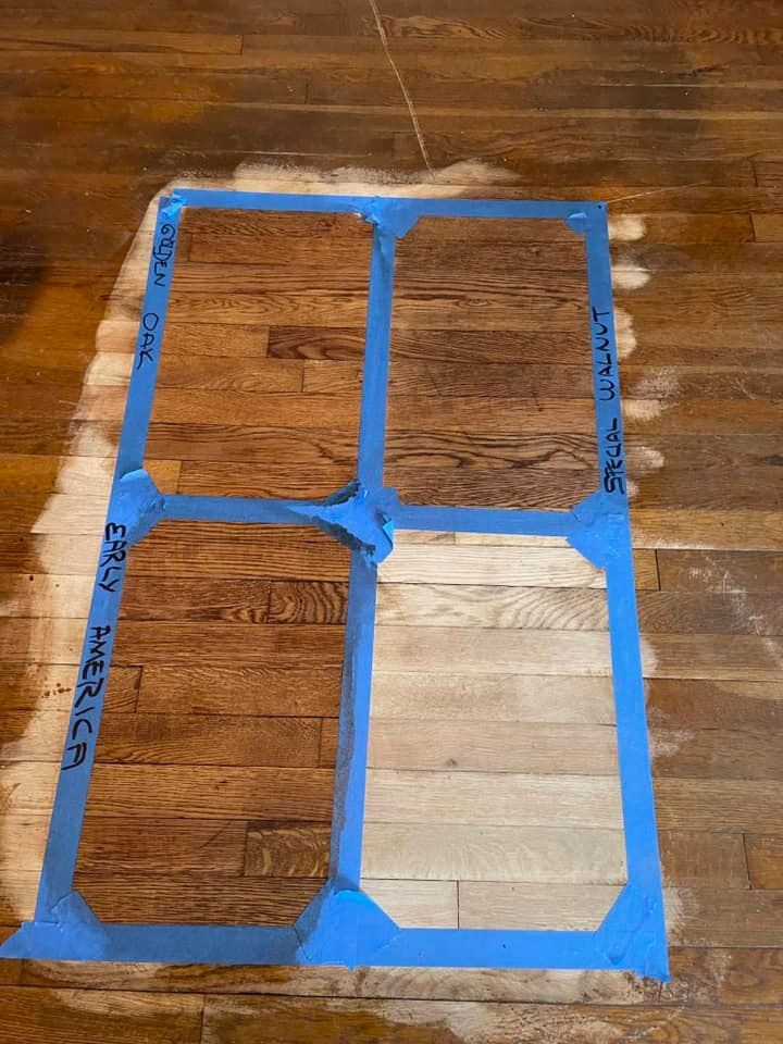A wooden floor with a blue tape on it that looks like a window.