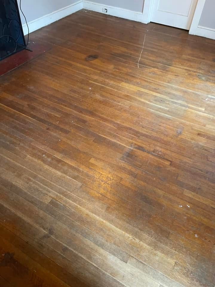 A wooden floor in a room with a fireplace.