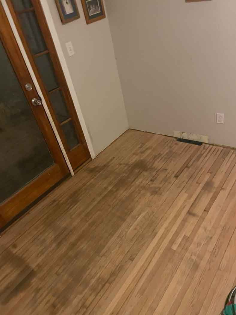 A wooden floor in a room with a sliding glass door.