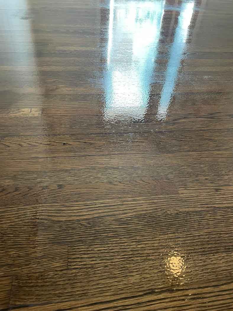 A close up of a wooden floor with a shiny finish.