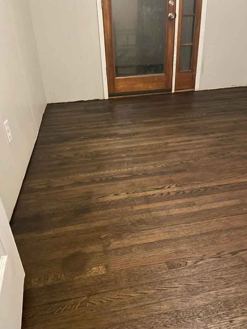 A room with a wooden floor and a glass door.