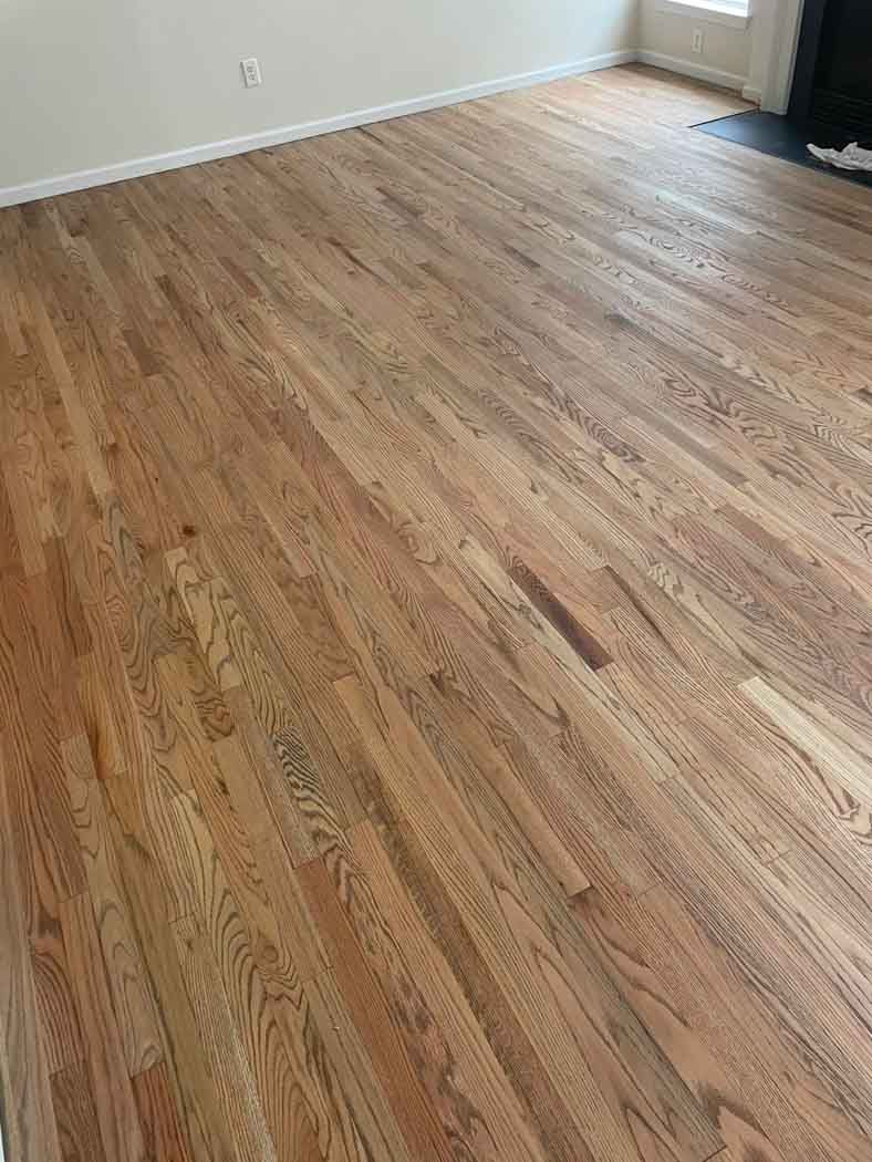 A living room with hardwood floors and a fireplace.
