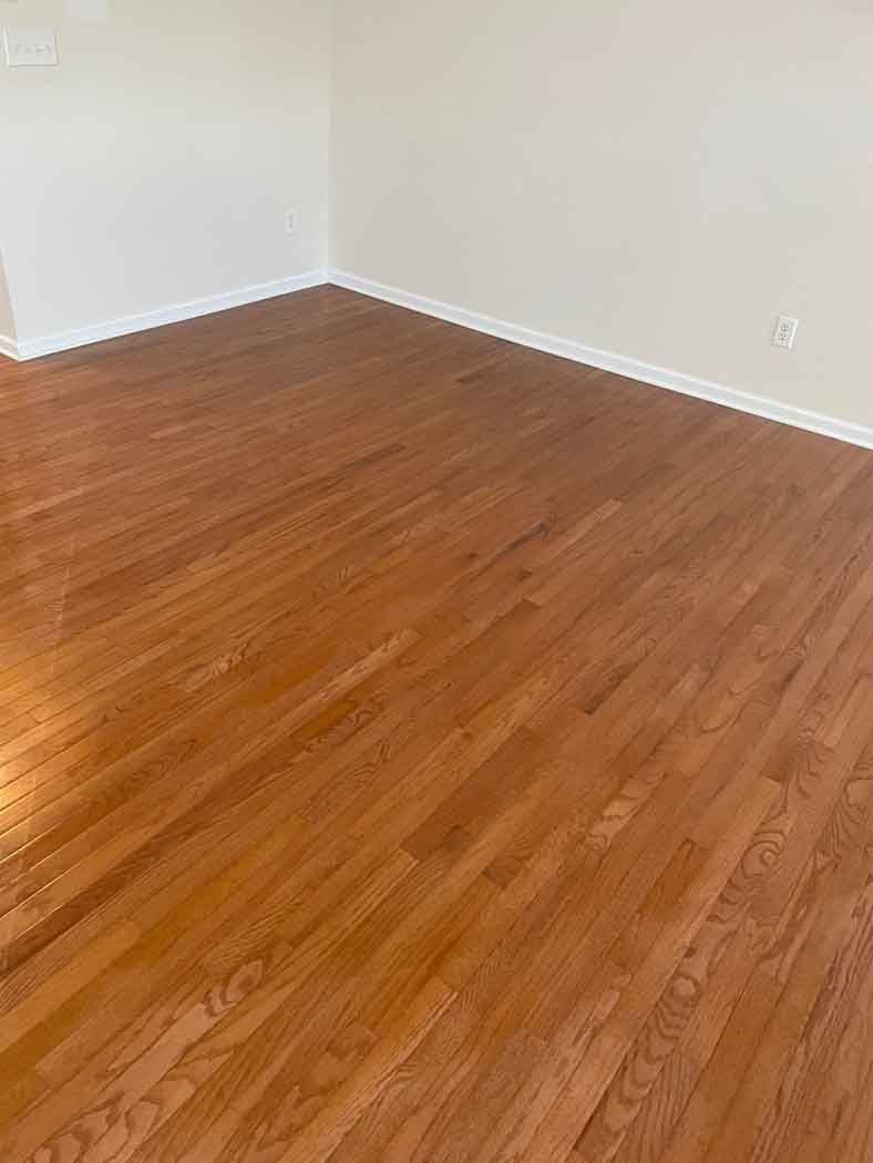 A living room with hardwood floors and white walls.