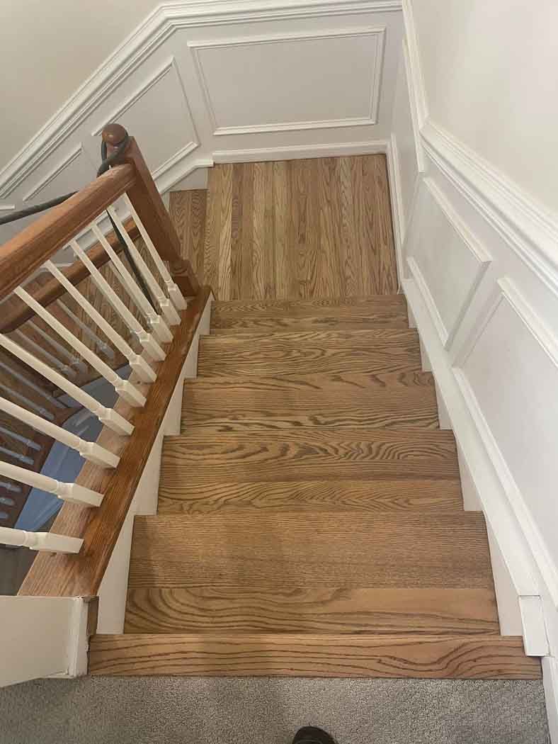 A wooden staircase with a white railing in a house.
