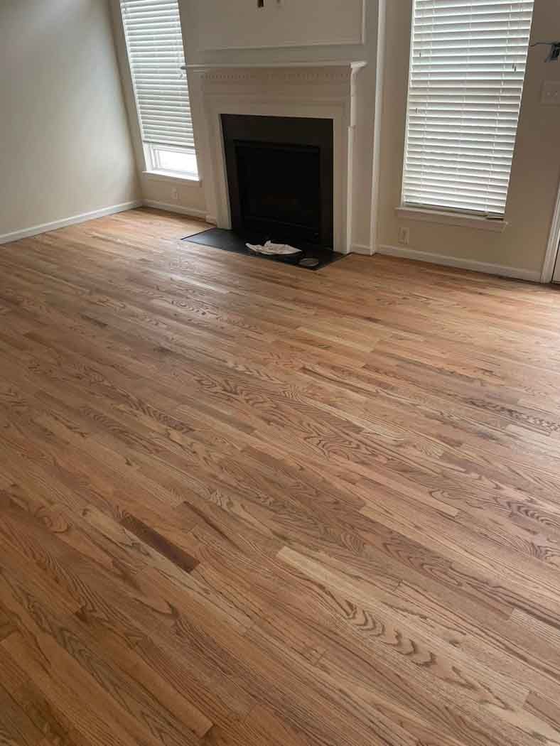 A living room with hardwood floors and a fireplace.