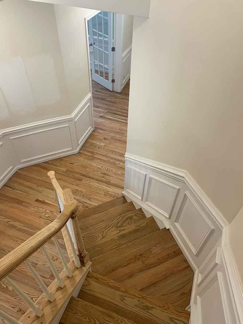 A staircase with wooden steps and white trim in a house.