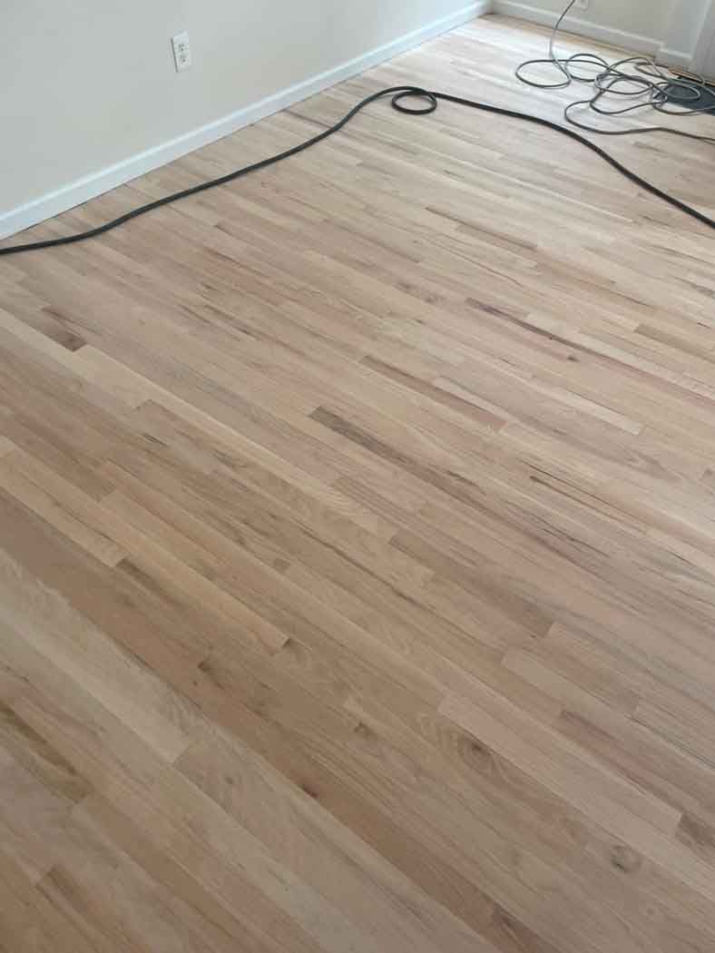 A wooden floor with a cord hanging from it in a room.