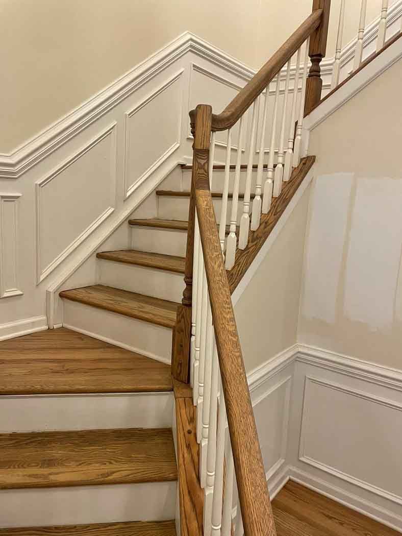 A staircase with wooden steps and a white railing in a house.