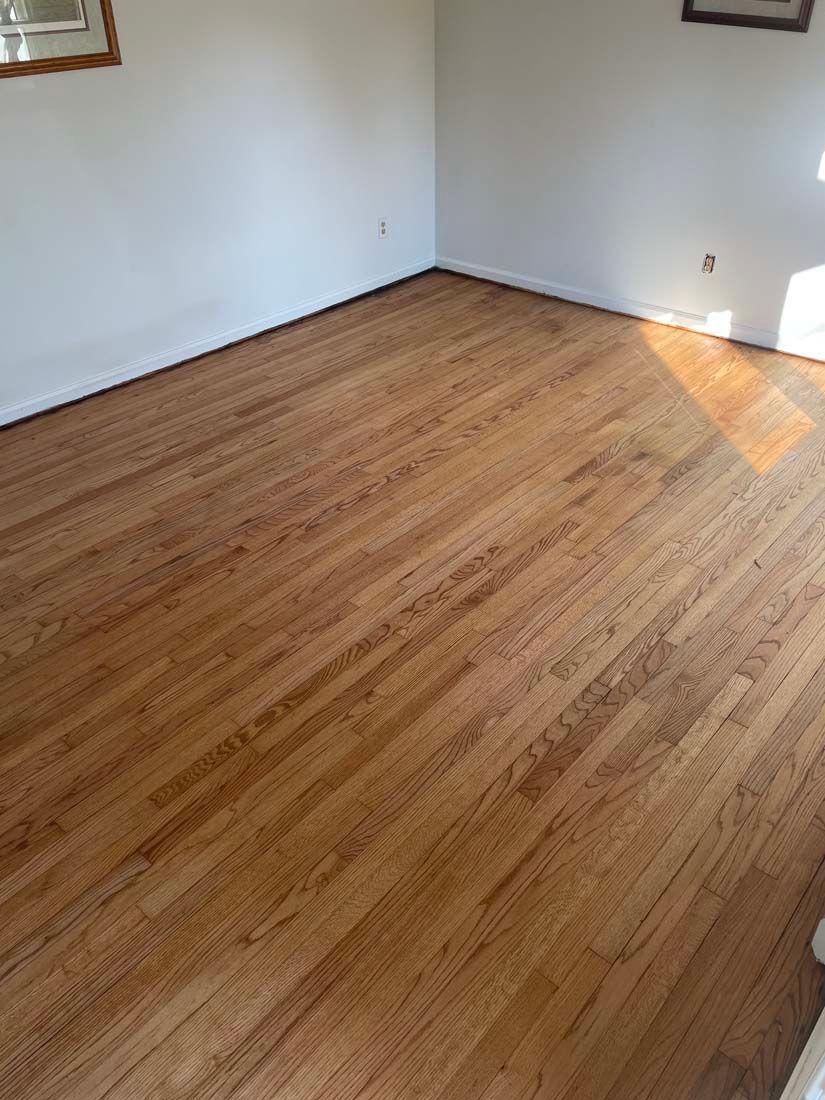 A living room with hardwood floors and white walls.