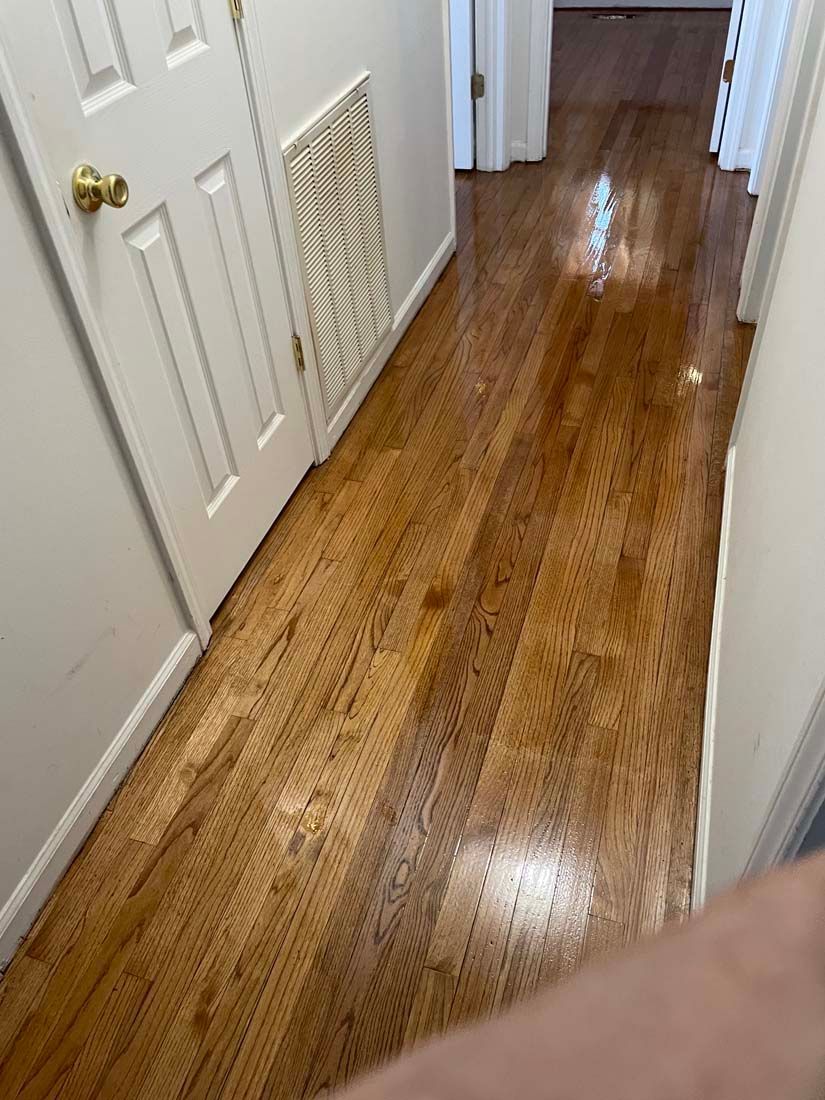 A hallway with hardwood floors and white doors in a house.