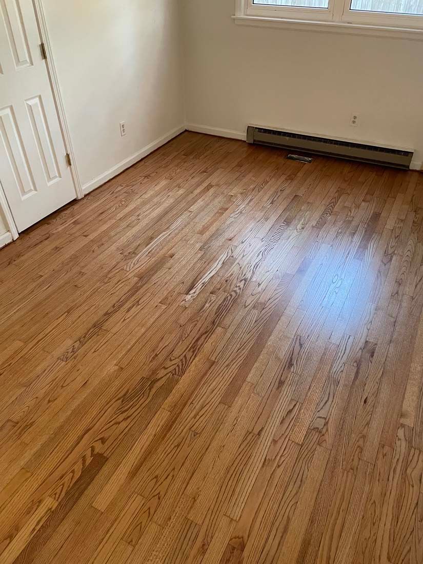 A room with hardwood floors and a window.