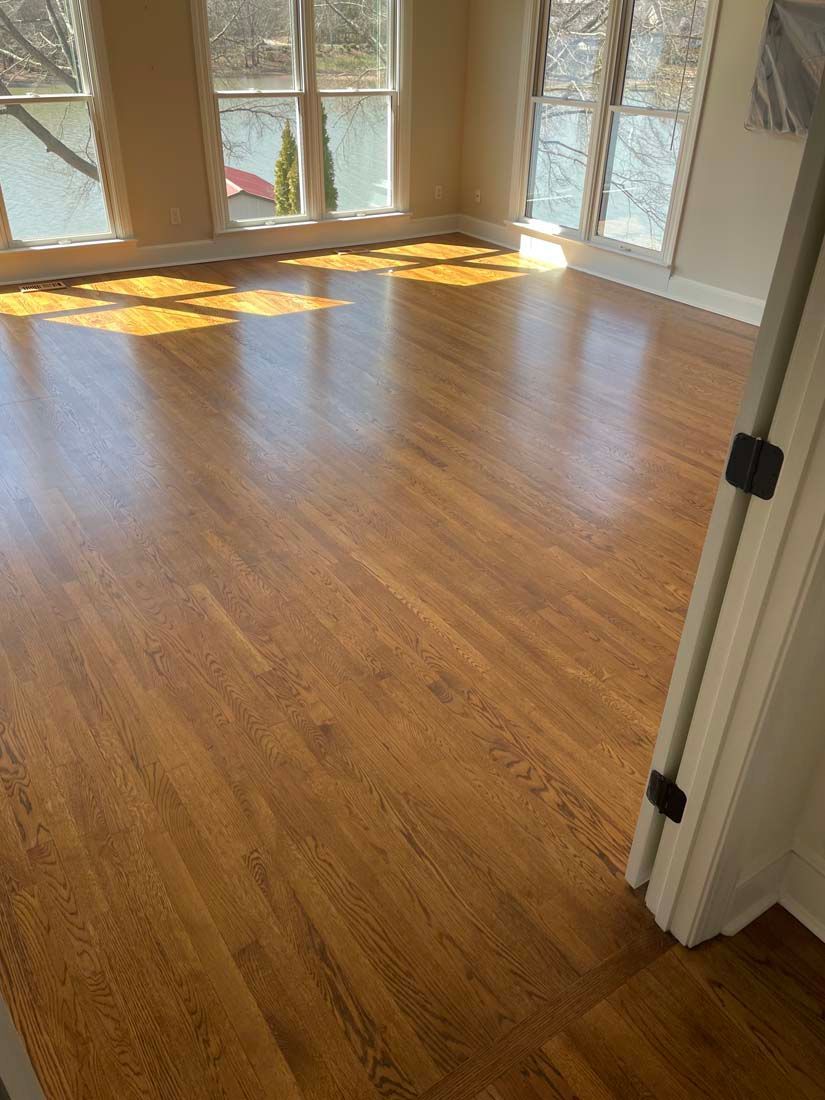 A living room with hardwood floors and lots of windows.