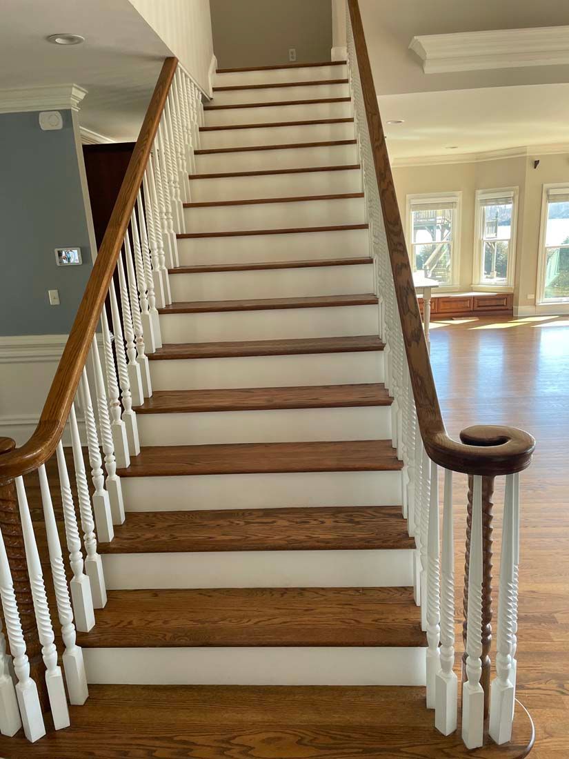 A staircase with wooden steps and a white railing in a house.