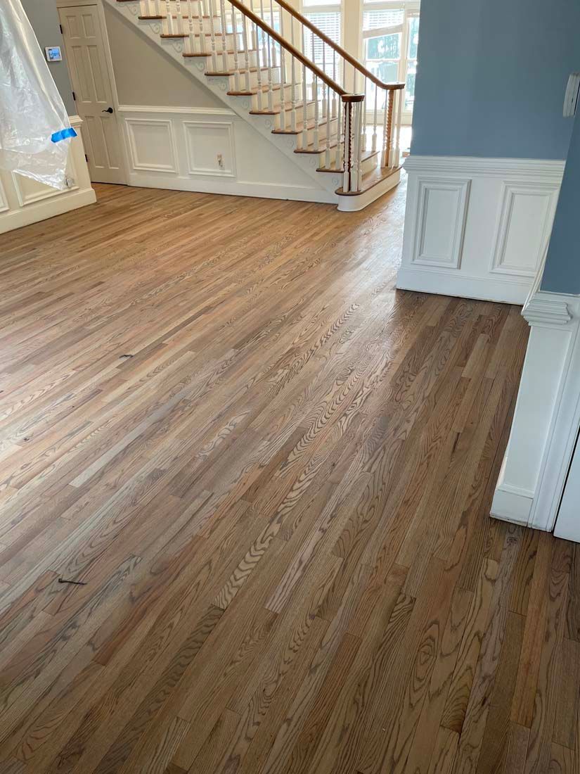 A living room with hardwood floors and a staircase.