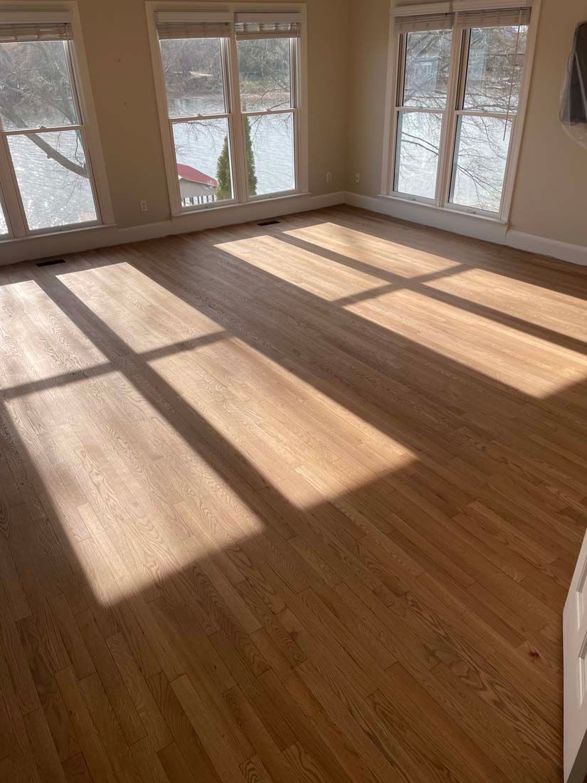 A living room with hardwood floors and lots of windows.