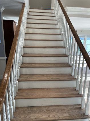A staircase with wooden steps and white railings in a house.