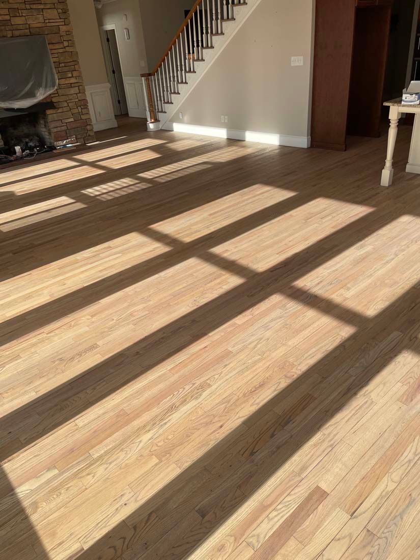 A living room with hardwood floors and a staircase.