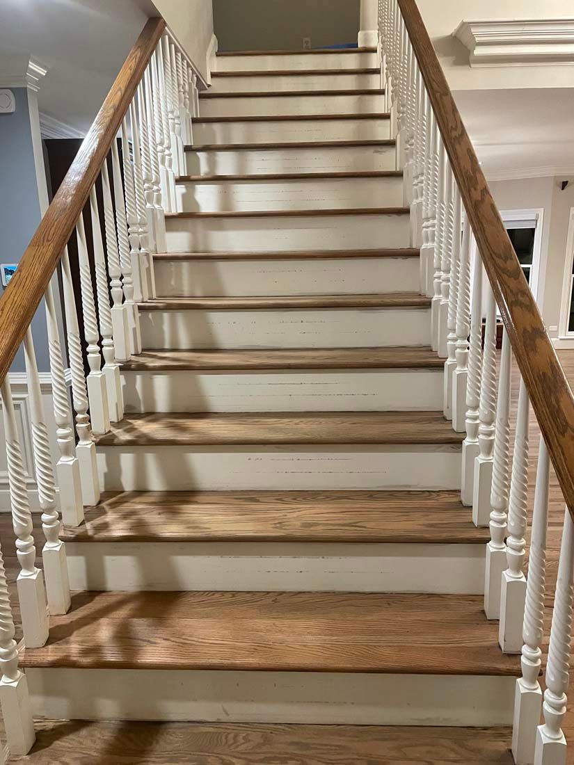 A staircase with wooden steps and white railings in a house.