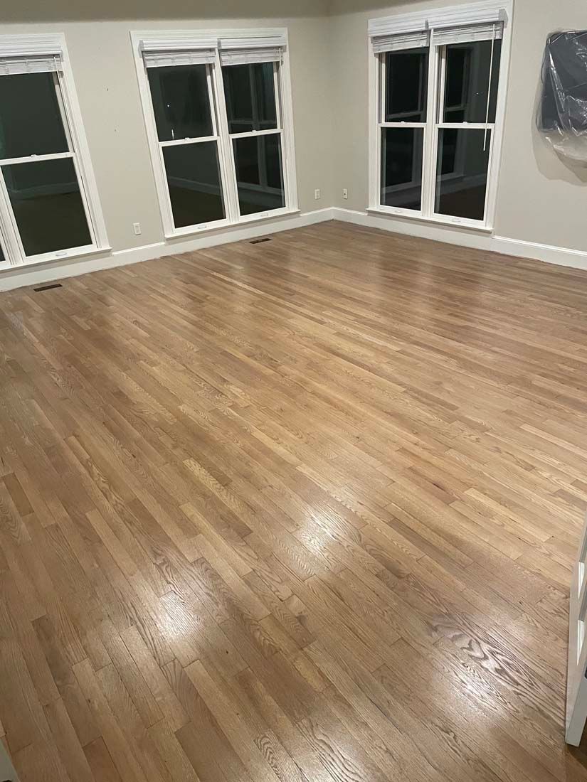 A living room with hardwood floors and lots of windows.