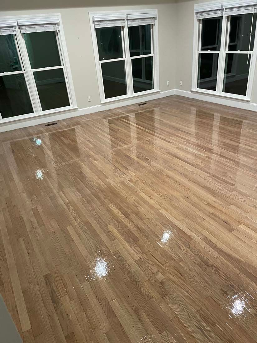 A living room with hardwood floors and lots of windows.