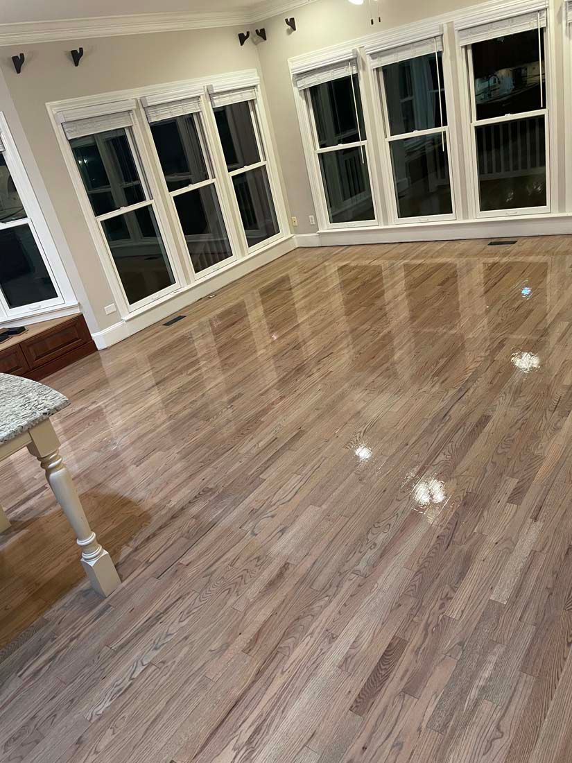 A living room with hardwood floors and lots of windows.