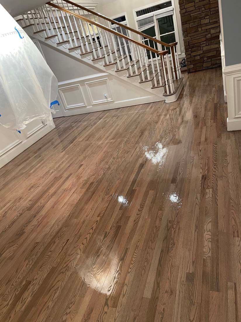 A living room with hardwood floors and a staircase.