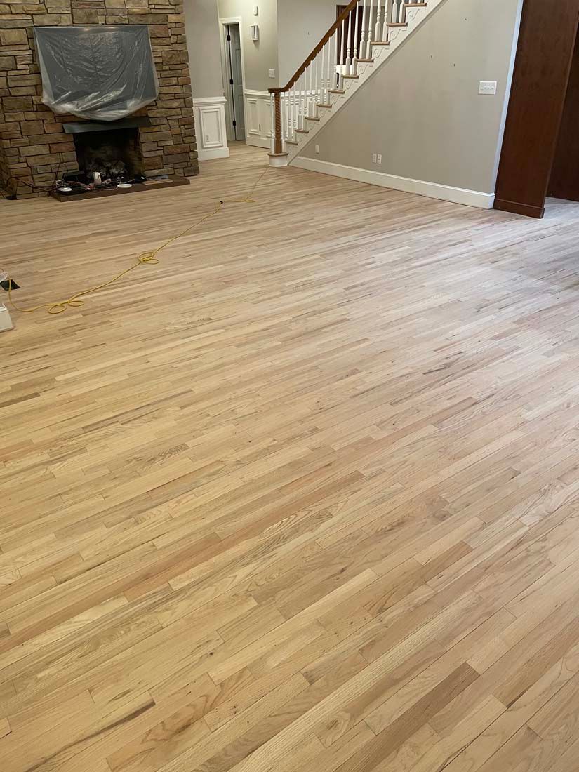 A living room with hardwood floors and a fireplace.