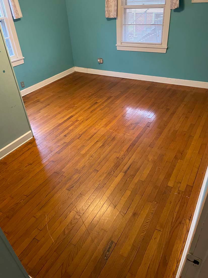 A bedroom with hardwood floors and blue walls.