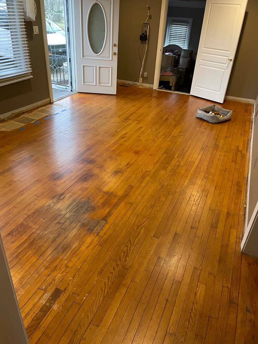 A living room with hardwood floors and a white door.