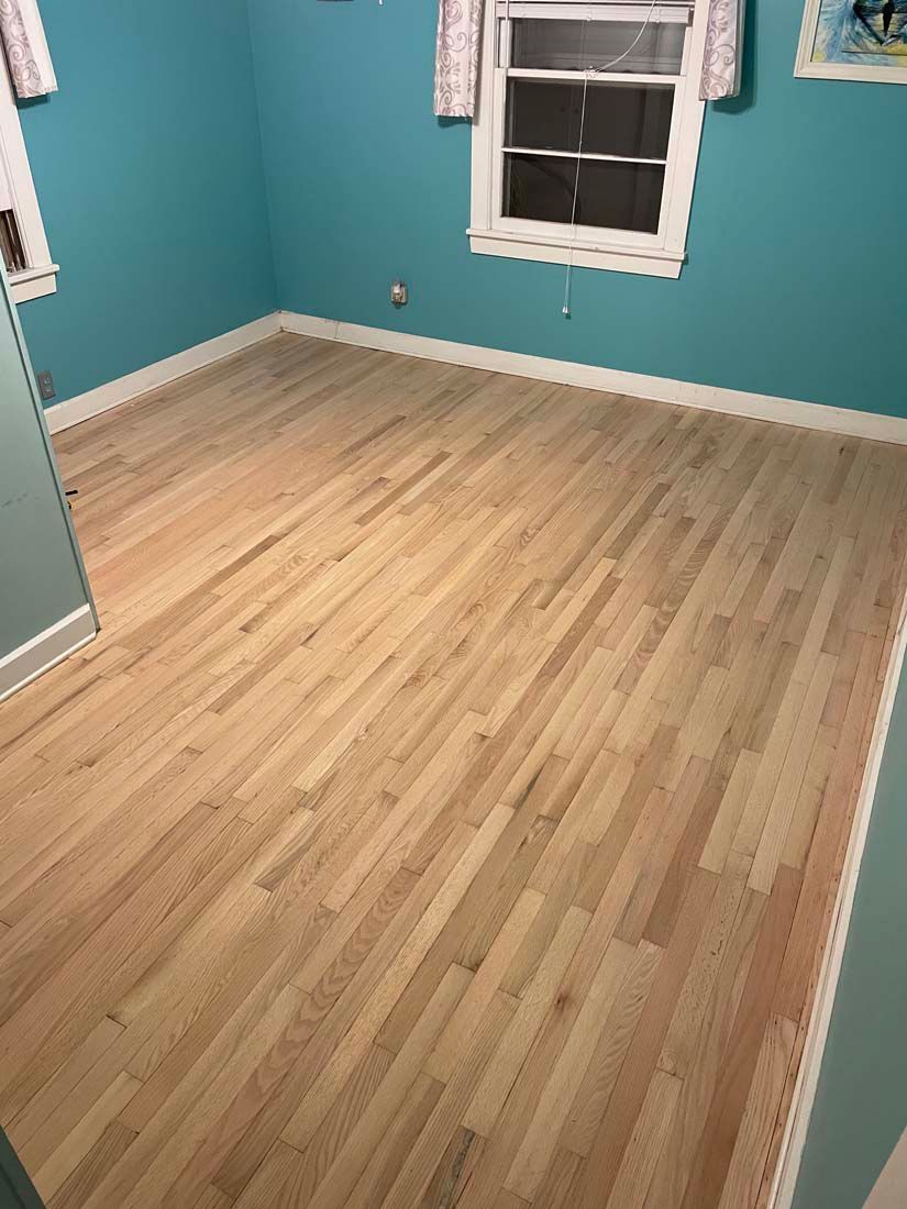 A bedroom with a wooden floor and blue walls.