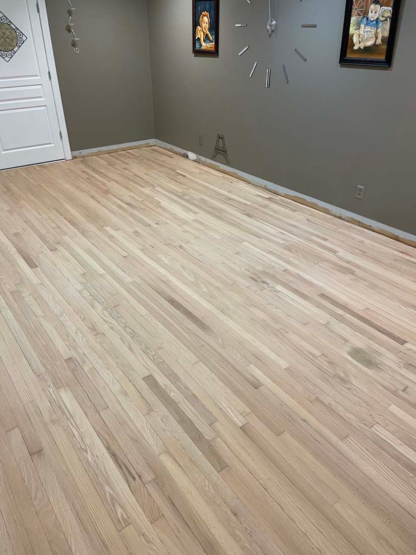 A room with a wooden floor and a clock on the wall.