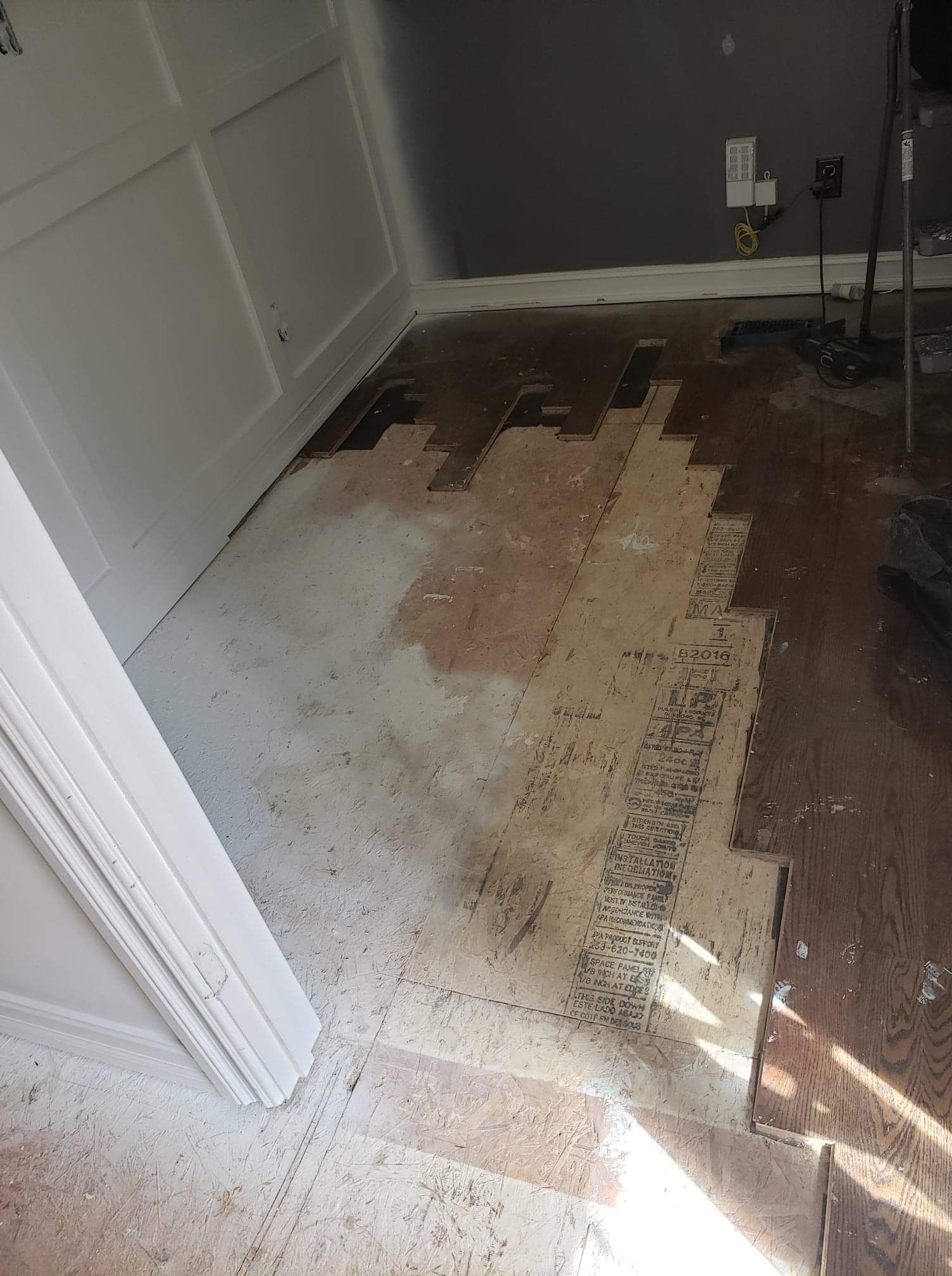 A room with a wooden floor and a white wall.